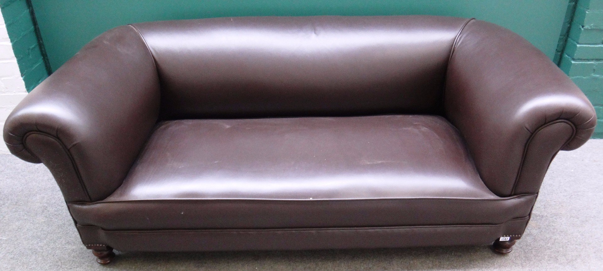 Appraisal: A th century later upholstered brown leather Chesterfield sofa on