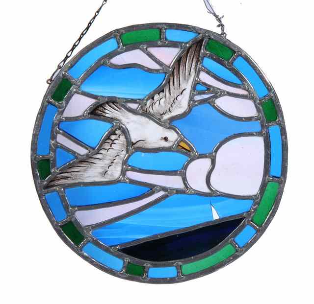 Appraisal: An Arts Crafts stained glass roundel depicting a bird in