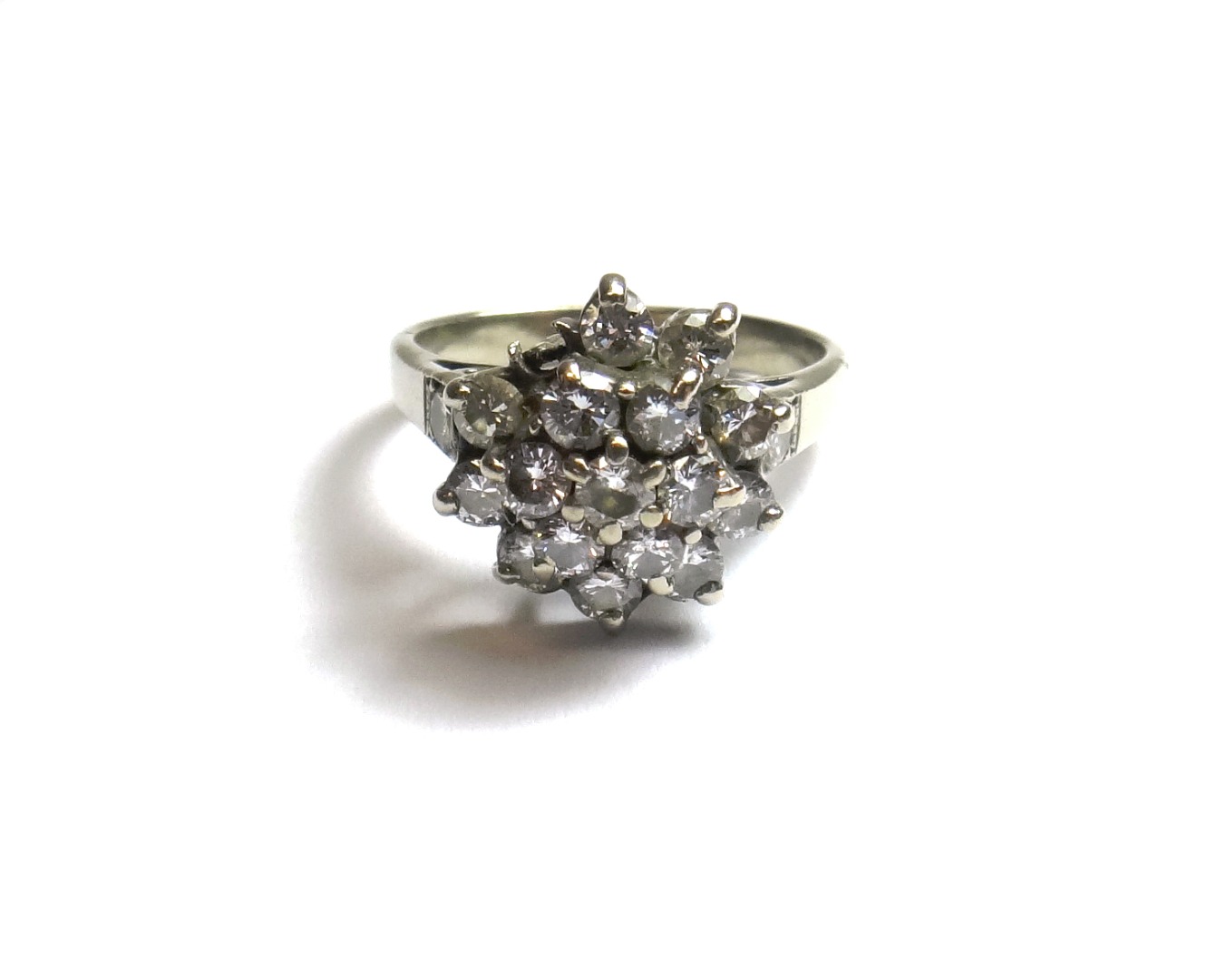 Appraisal: A diamond set cluster ring claw set with circular cut