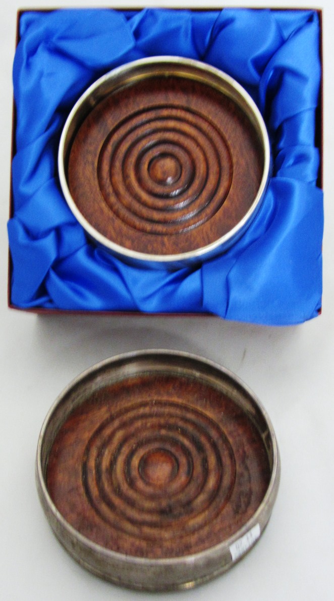 Appraisal: A silver mounted circular bottle coaster with a turned wooden