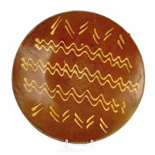 Appraisal: Pennsylvania redware charger th c with yellow slip wavy line