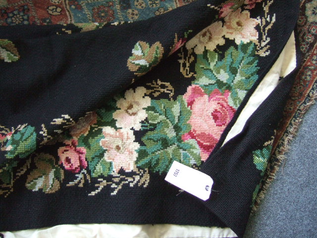 Appraisal: A needlepoint rug the plain black field with a rose