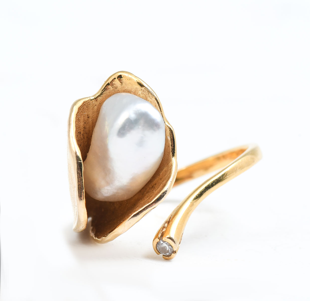 Appraisal: MODERN K PEARL RING WITH DIAMOND Graceful stylized bypass ring