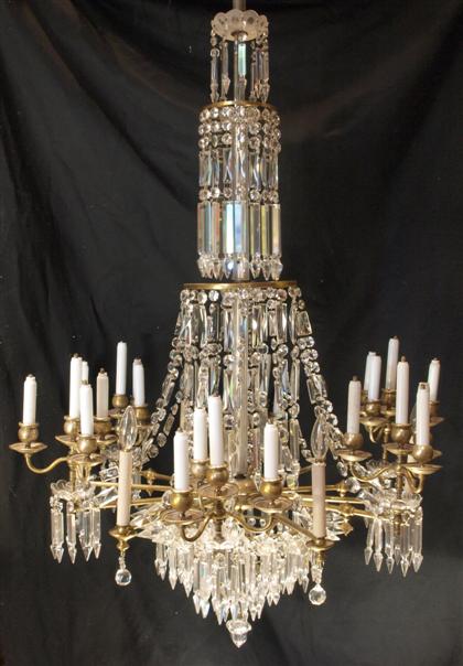 Appraisal: Empire style gilt metal and glass twenty light chandelierHung with