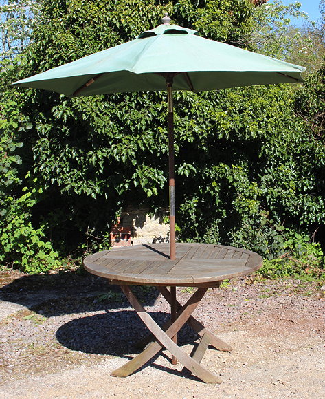 Appraisal: A CIRCULAR TEAK FOLDING GARDEN TABLE cm diameter and a