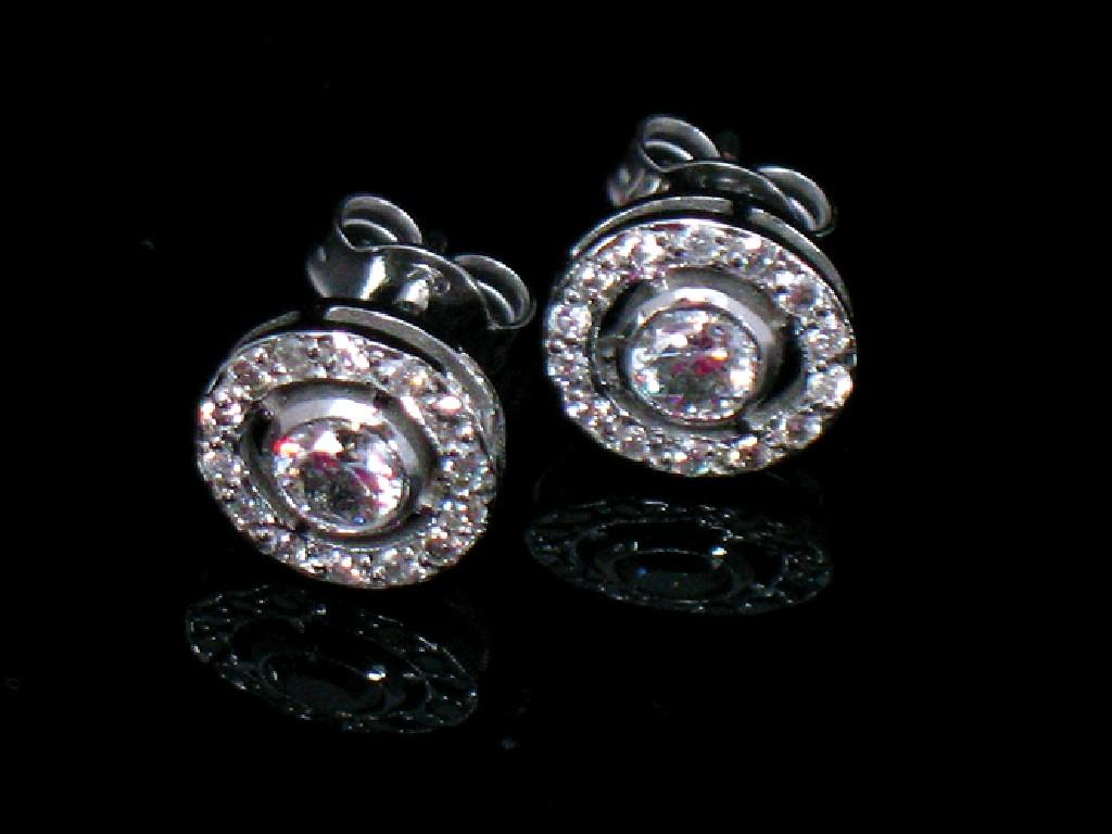 Appraisal: A PAIR OF MODERN DIAMOND CLUSTER EARRINGS each collet-set with