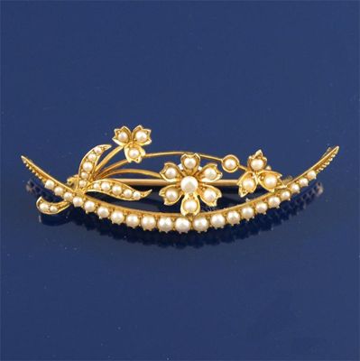 Appraisal: An Edwardian seed pearl set gold open crescent and floral