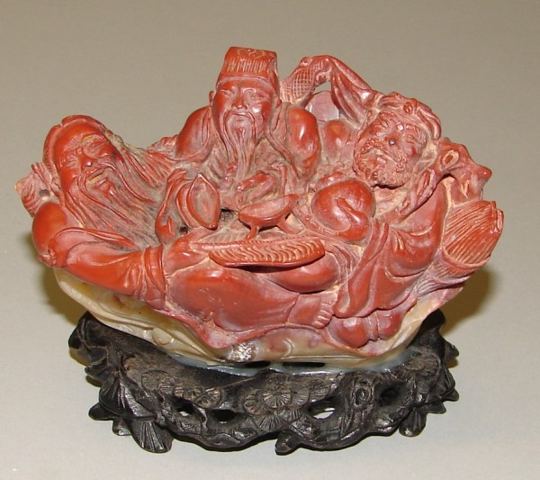 Appraisal: Soapstone group features three sages seated together hodling various items