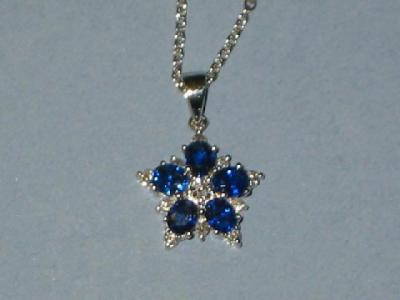 Appraisal: A SAPPHIRE AND DIAMOND PENDANT modelled as a flowerhead with