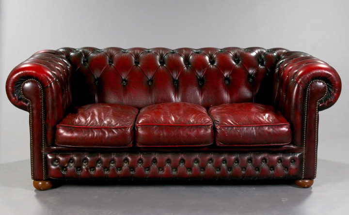 Appraisal: Oxblood Leather Chesterfield the tufted back wrapping around to similarly