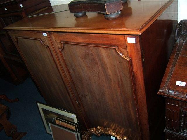 Appraisal: A mahogany linen press with panelled doors standing on bracket