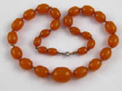 Appraisal: An amber bead necklace approx cm long largest bead approx