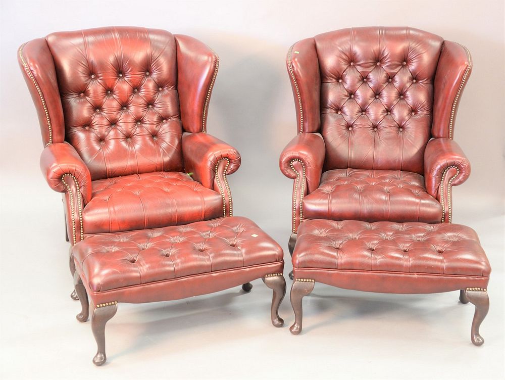 Appraisal: Pair of tufted leather upholstered wing chairs both with ottomans