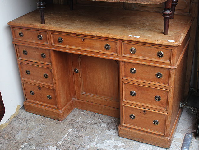 Appraisal: A PINE KNEEHOLE DESK with nine drawers around the central