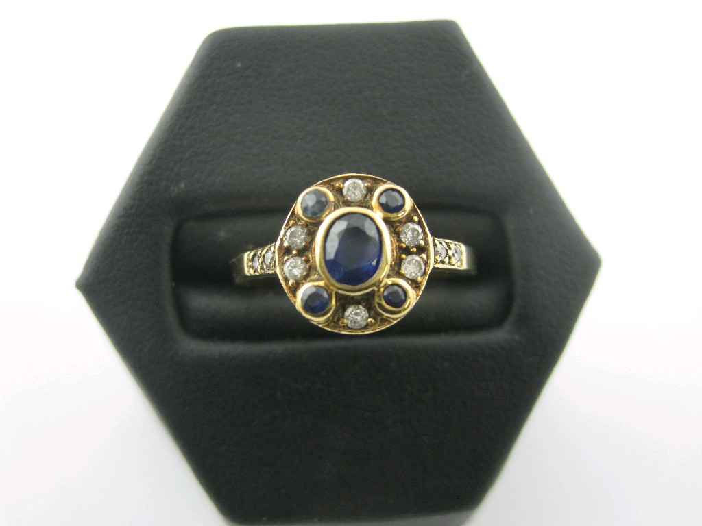 Appraisal: A Sapphire and Diamond Cluster Ring the central oval-cut sapphire