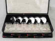 Appraisal: A boxed cocktail set of six glasses with silver coasters