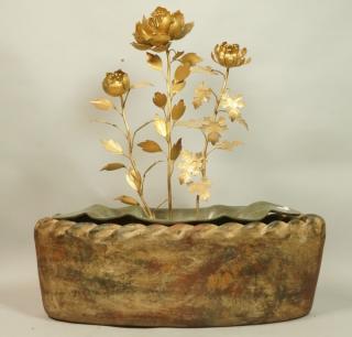 Appraisal: Gold metal flowers set in concrete sit in fluted metal