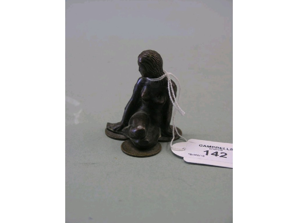 Appraisal: A small bronze model of a mermaid seated upon three