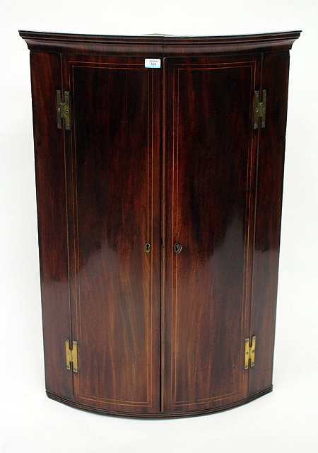 Appraisal: A GEORGE III MAHOGANY BOW FRONTED CORNER CABINET with satinwood