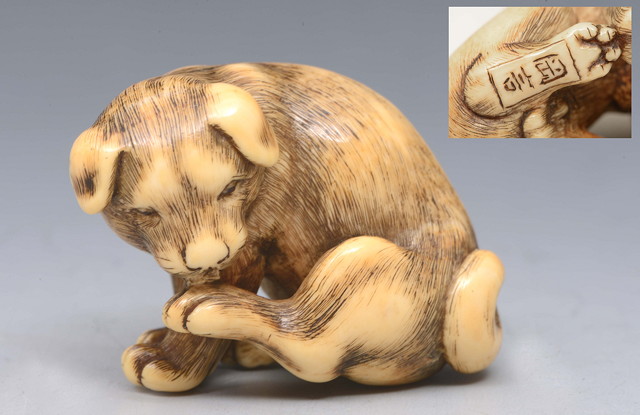 Appraisal: AN IVORY NETSUKE of a puppy by Okakoto late th