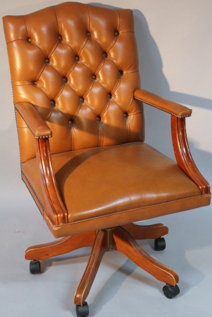 Appraisal: A thC swivel office chair upholstered in brown studded leather