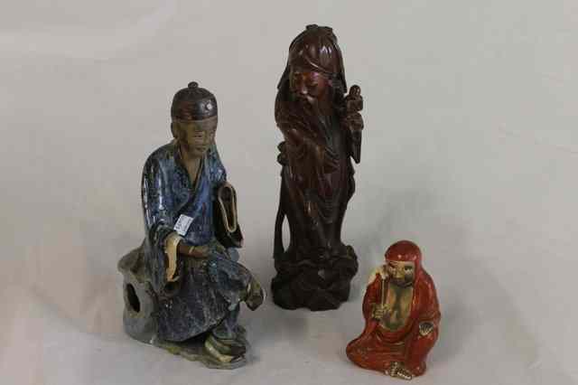 Appraisal: A CHINESE CARVED HARDWOOD FIGURE holding a ruyi sceptre in