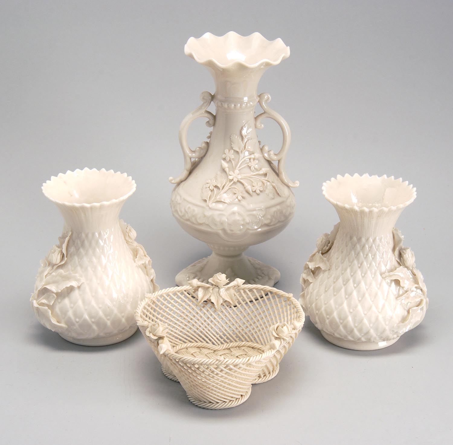 Appraisal: FOUR PIECES OF BELLEEK PORCELAIN a two-handled vase with applied