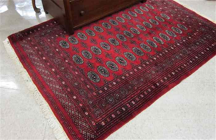 Appraisal: RED FIELD BOKHARA AREA RUG Indo-Turkoman hand knotted wool '