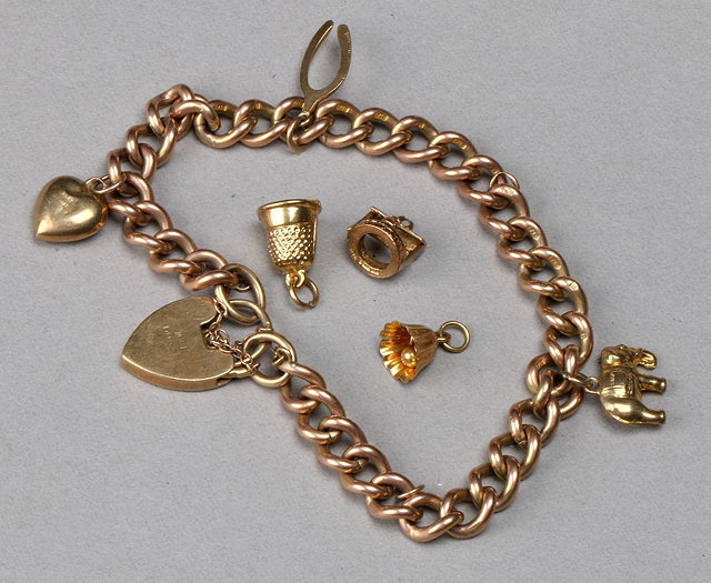 Appraisal: A CT GOLD CURB LINK BRACELET with three attached charms