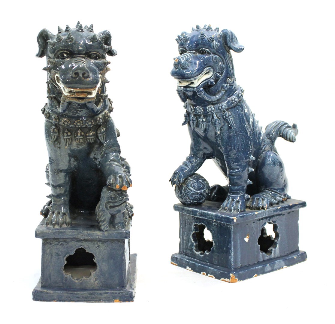 Appraisal: A pair of Chinese blue glazed pottery seated Buddhist lions