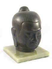 Appraisal: A Buddha head ht cm on stone plinth