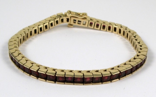 Appraisal: GARNET AND FOURTEEN KARAT GOLD BRACELET with square facet-cut garnets