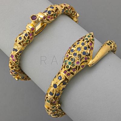 Appraisal: TWO INDIAN JEWELED GILT METAL HINGED BRACELETS Coiled serpent and