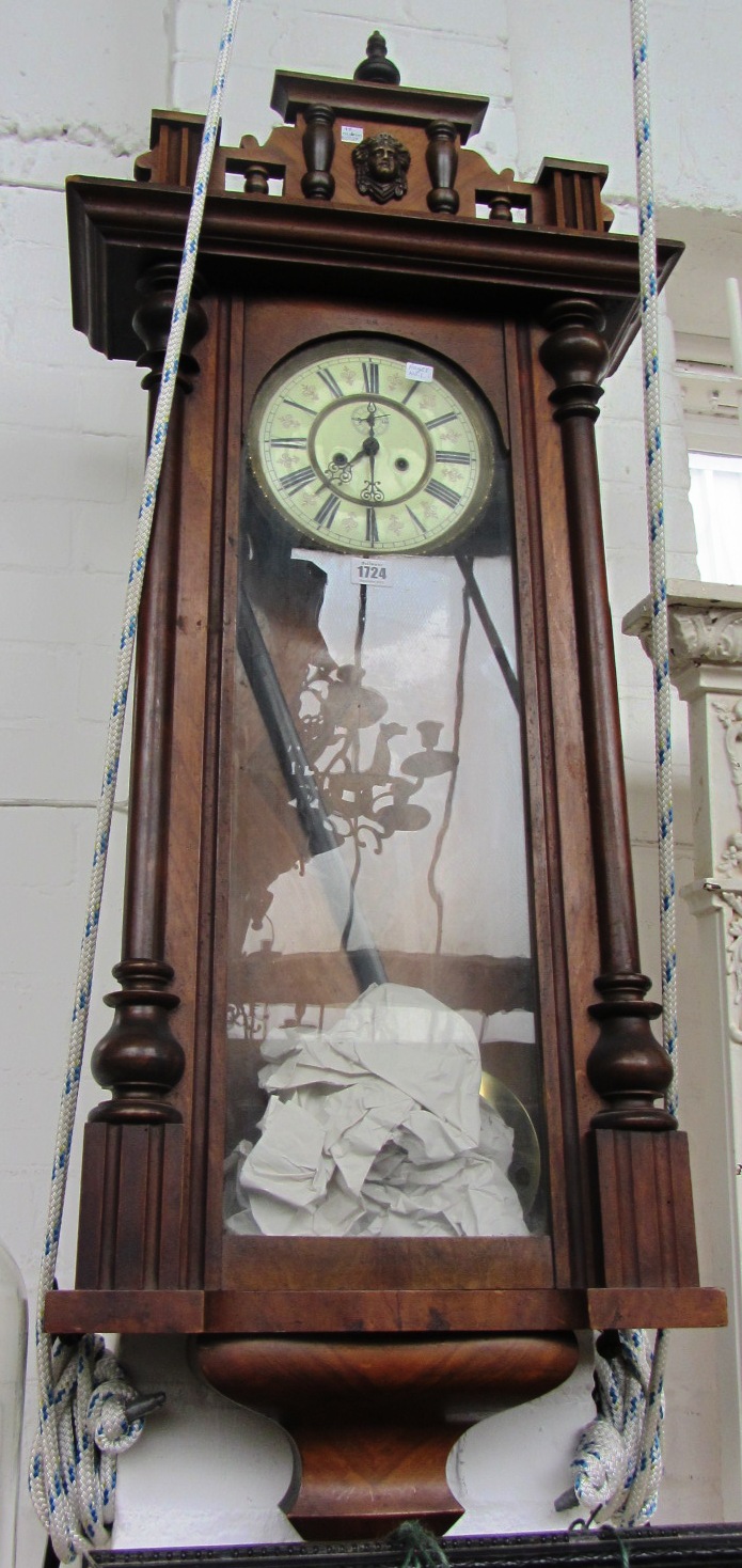 Appraisal: A walnut cased Vienna wall clock with turned finial glazed