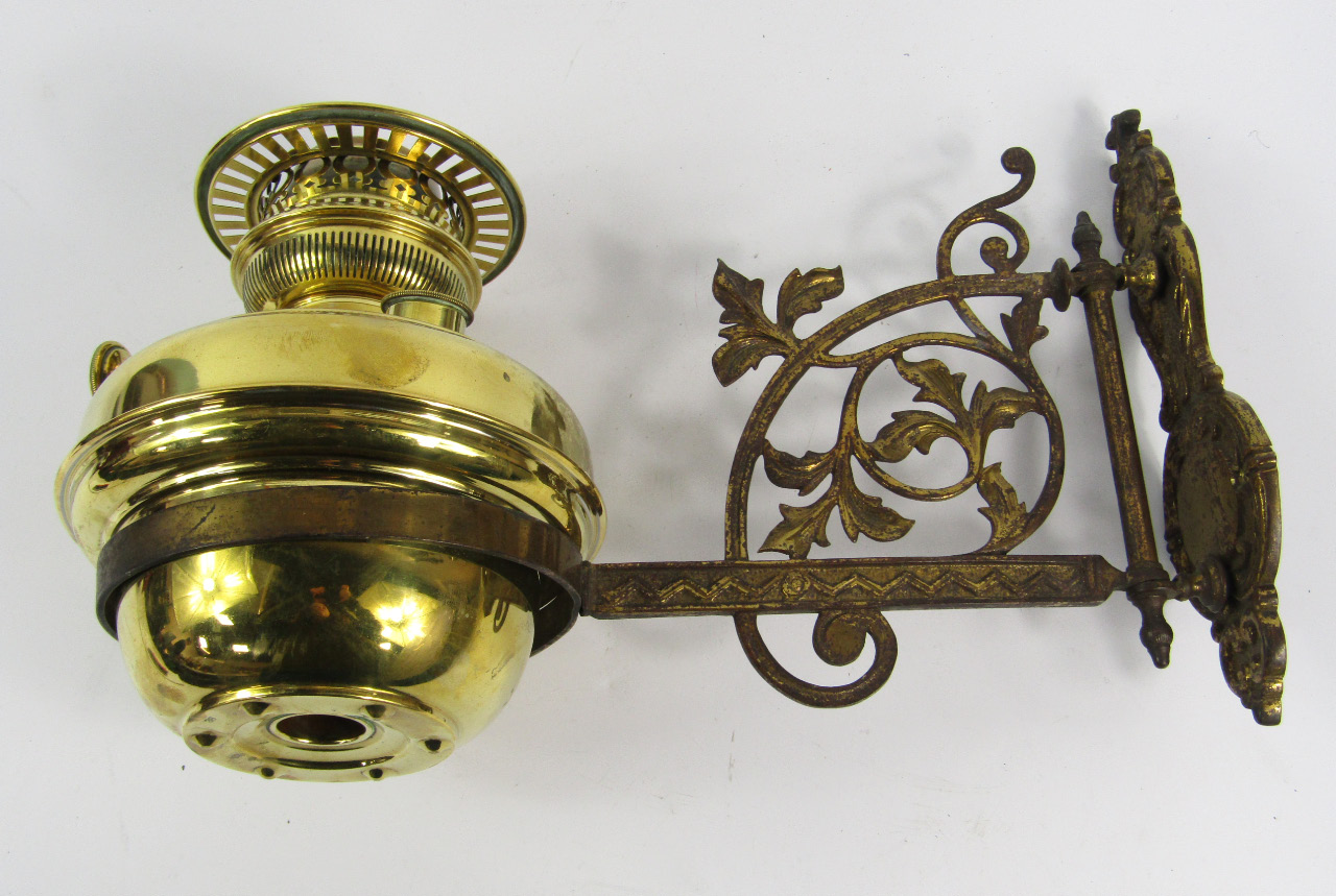 Appraisal: A Victorian brass wall mounted oil lamp the bracket cast