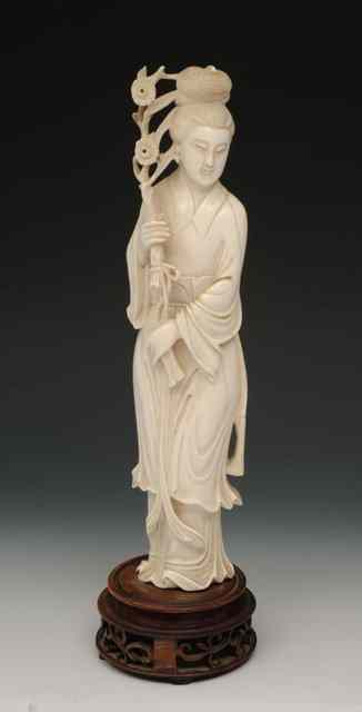 Appraisal: A CHINESE IVORY CARVED MODEL of Guanyin holding a flower