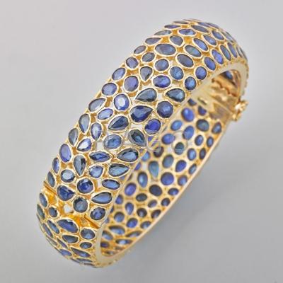 Appraisal: SAPPHIRE K YELLOW GOLD BROAD HINGED BANGLE Approx faceted blue