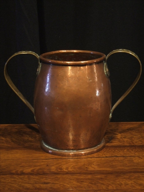 Appraisal: COPPER TWO-HANDLED CUP The copper gobular body with two curved