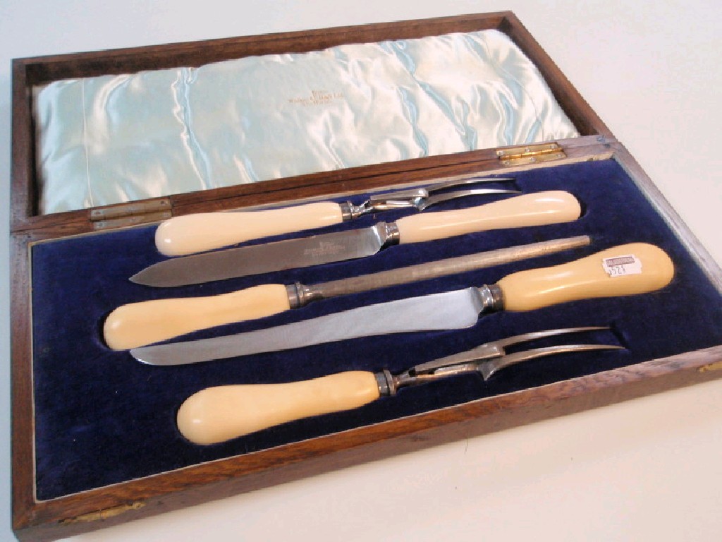 Appraisal: An oak cased carvery set with ivory handles