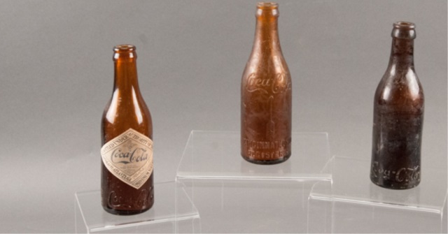 Appraisal: Three Brown Glass Coca-Cola Bottles H