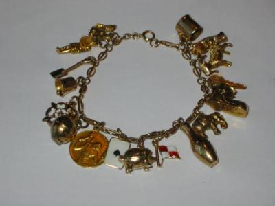 Appraisal: A CT GOLD CHARM BRACELET hanging with seventeen charms including