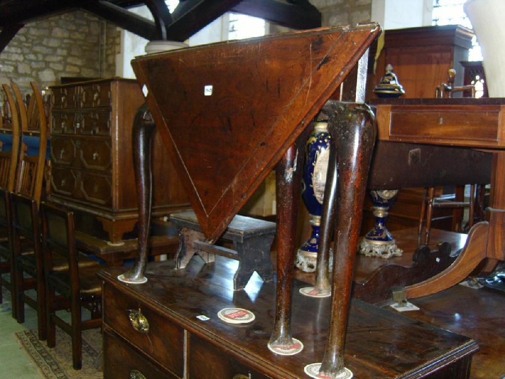 Appraisal: An th century walnut drop leaf corner table raised on