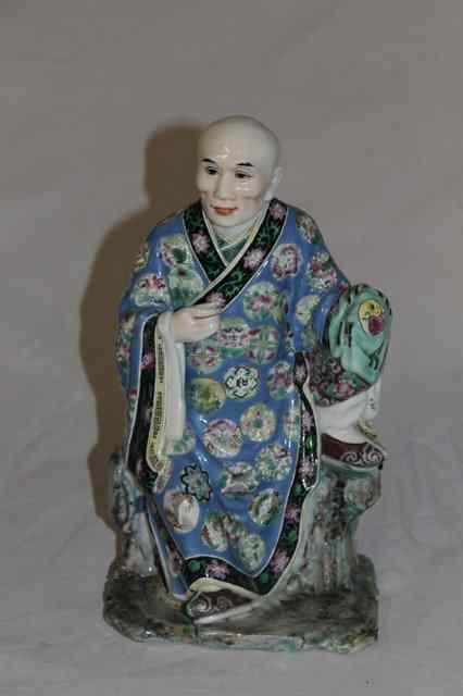 Appraisal: A CHINESE POLYCHROME PORCELAIN MODEL OF AN OFFICIAL his blue