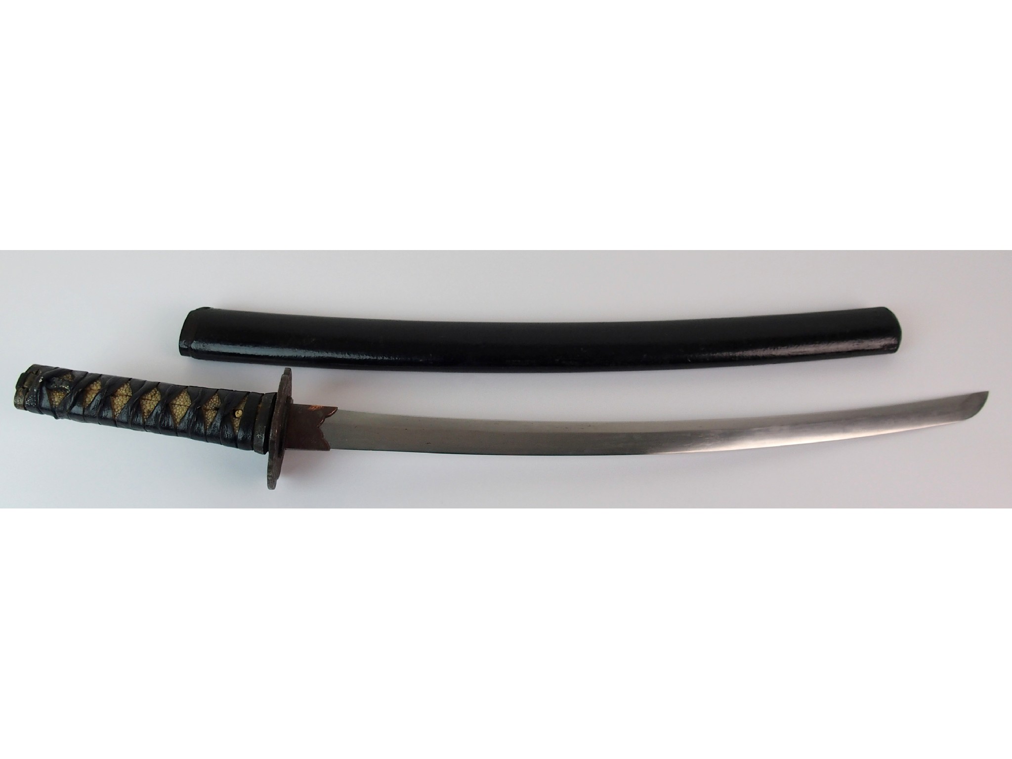 Appraisal: A Japanese short swordthe sharkskin covered hilt leather bound with