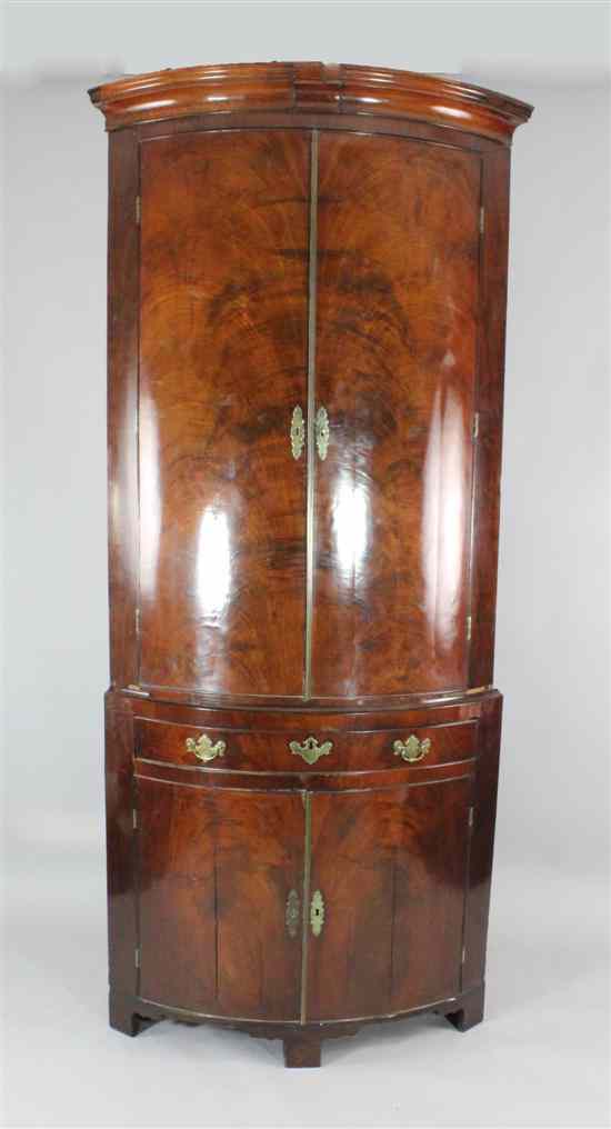 Appraisal: A George II bowfront mahogany corner cupboard with two doors