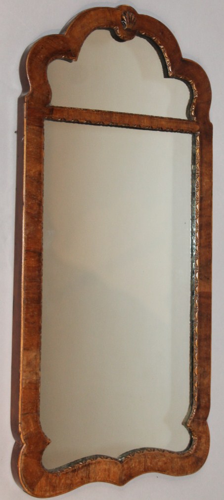 Appraisal: A thC walnut wall mirror of shaped outline headed by