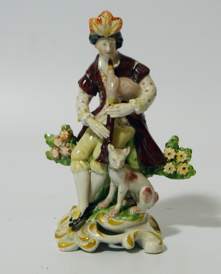 Appraisal: A thC Pearlware figure of a piper aside dog on