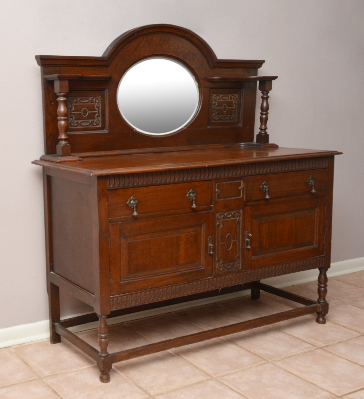 Appraisal: WALNUT CARVED SIDEBOARD Arched crest central oval mirror open shelves