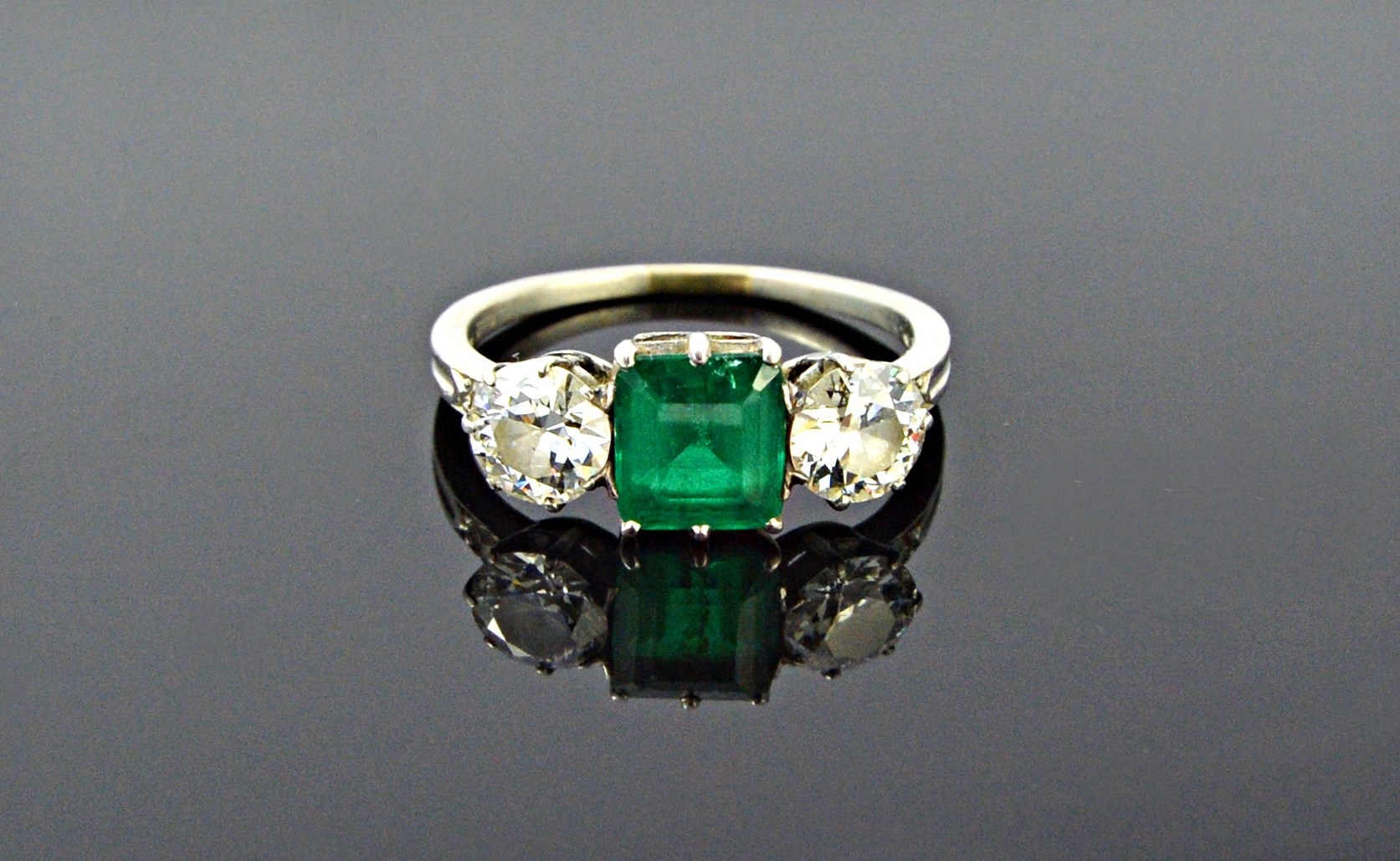 Appraisal: A platinum diamond and emerald set three stone ring claw