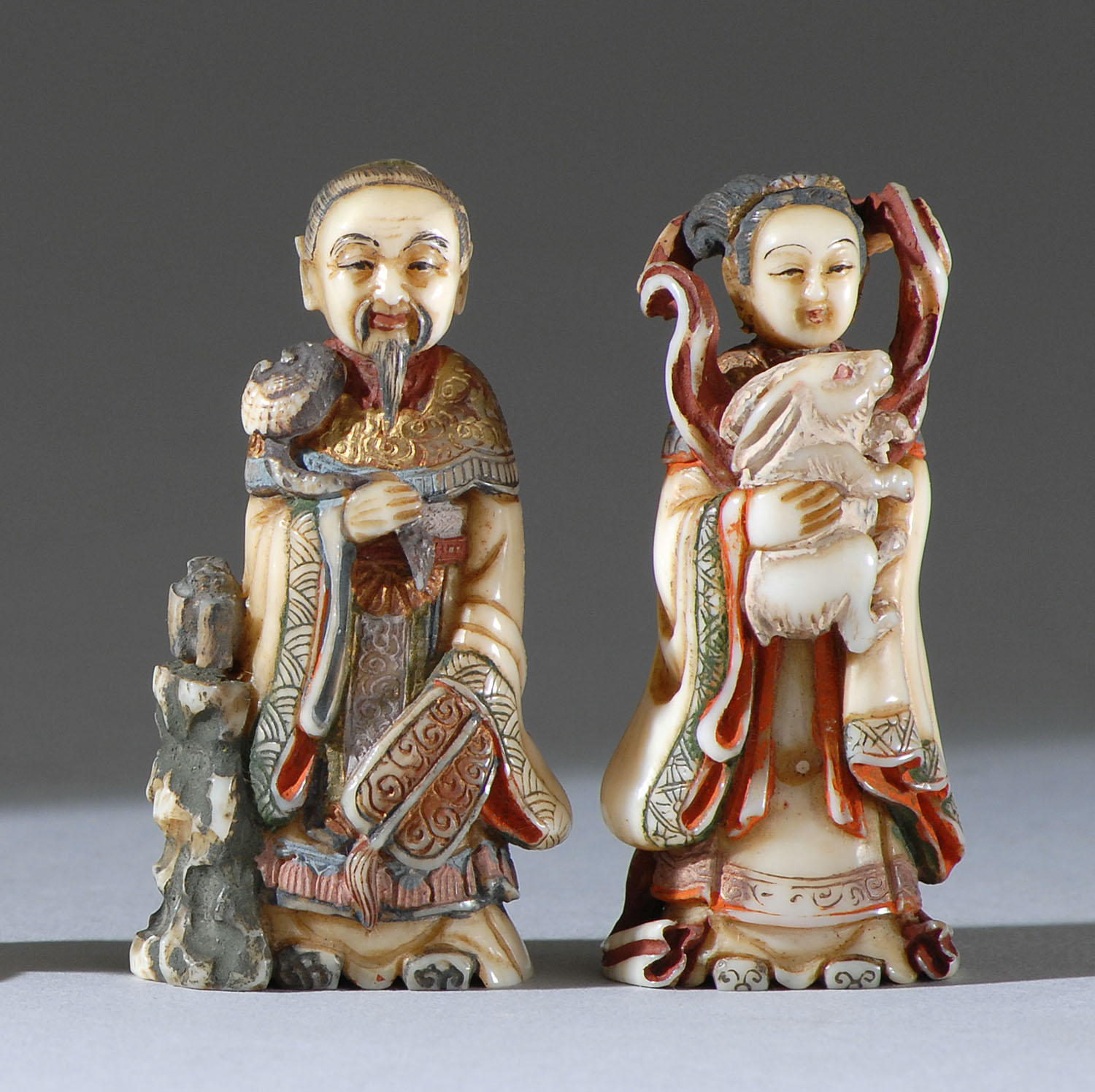 Appraisal: TWO POLYCHROME IVORY NETSUKE Circa By Akihiro Depicting a man